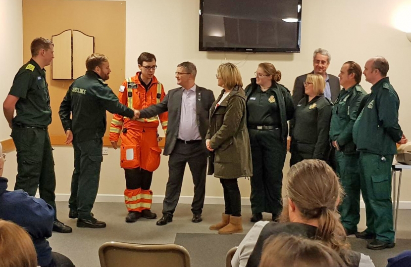 The team from EEAST which saved County Councillor Kevin Cuffley's life after he suffered a massive heart attack on 12th June 2018.  L to R: George Smith, David Killingback, Dr Scott Knapp, Kevin Cuffley (patient), Carol Cuffley, Hannah Fryer, Bryony Oxborrow, Pete Meads and Harvey Steven.  Councillor Brian Milnes, who did the initial CPR on Kevin, is standing behind Kevin and Carol.