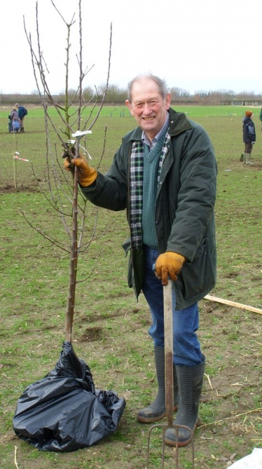 District Councillor Ray Manning planting an Egremont Russet apple tree at Coton 